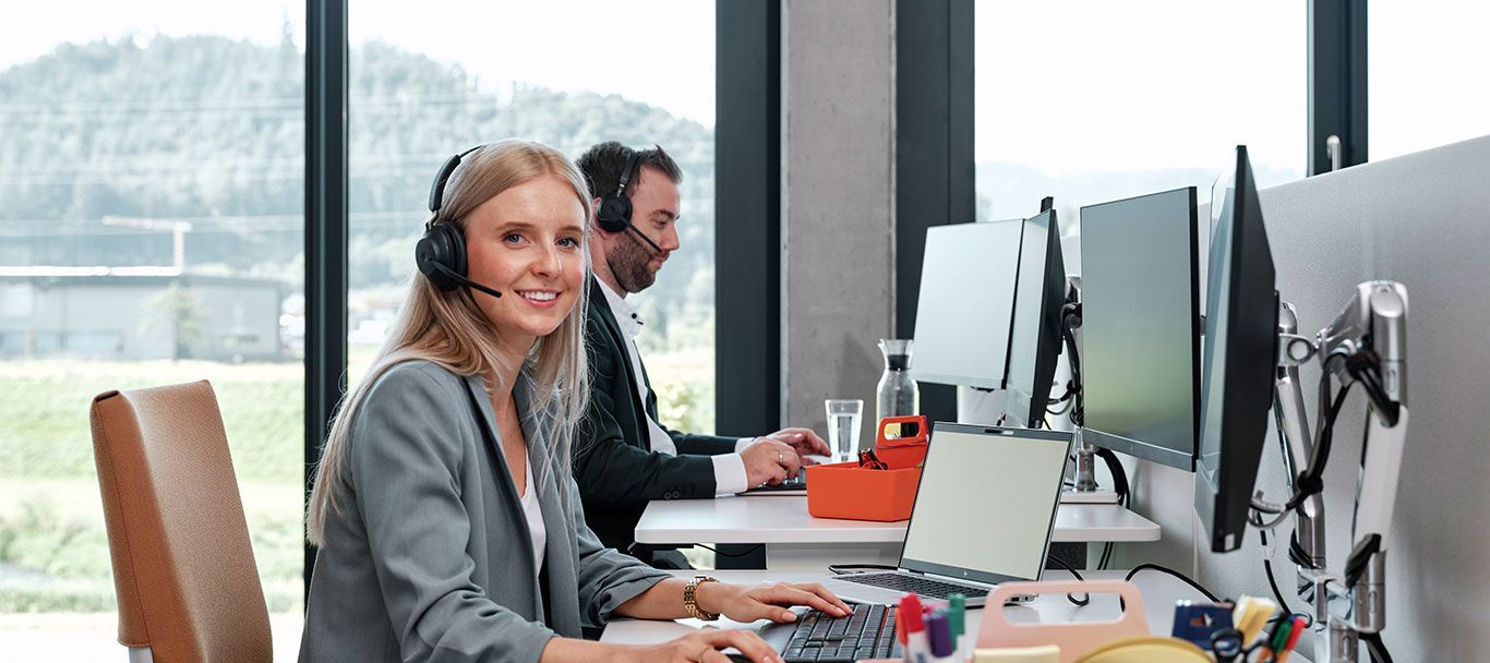 Kundenservice Mitarbeiter von Streit Service & Solution sitzt am Schreibtisch und telefoniert mit Headset