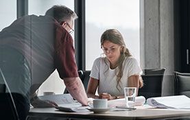 Mitarbeiter von Streit Service & Solution arbeiten zusammen an einem Tisch und schauen auf einen Plan.