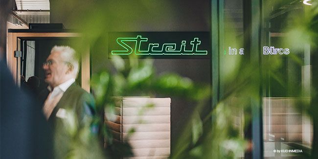 Arbeitswelt von Streit Service & Solution in Gengenbach bei einer Veranstaltung. Schild mit grüner Schrift hängt an der Wand.