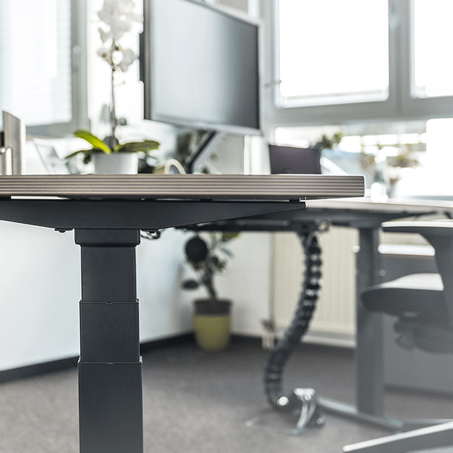 Schreibtisch mit Technik und ordentlich verstauten Kabeln
